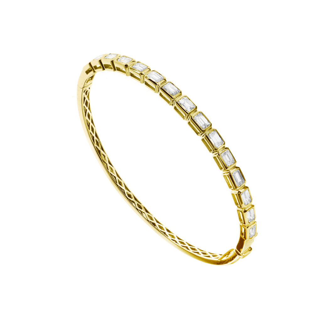 18KT yellow gold bangle with 3.50ctw bezel set emerald cut d...